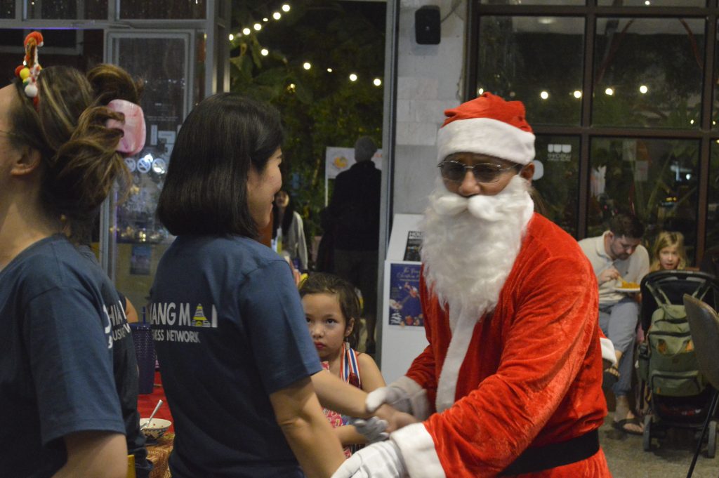 Santa interacting with children and adults
