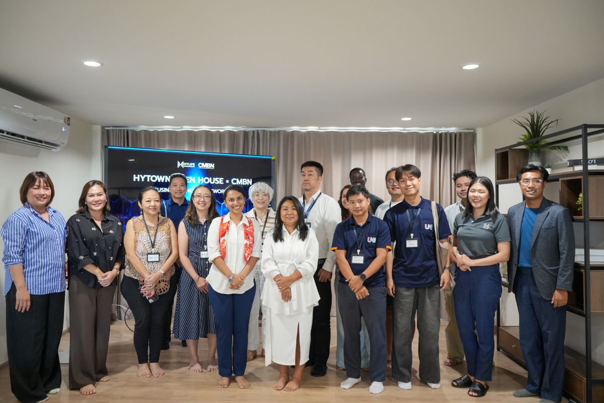 Group photo of members, guests and the Hylife team in front of the event screen